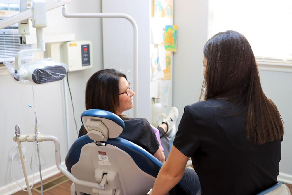 woman sitting in a dental chair getting full smile makeovers